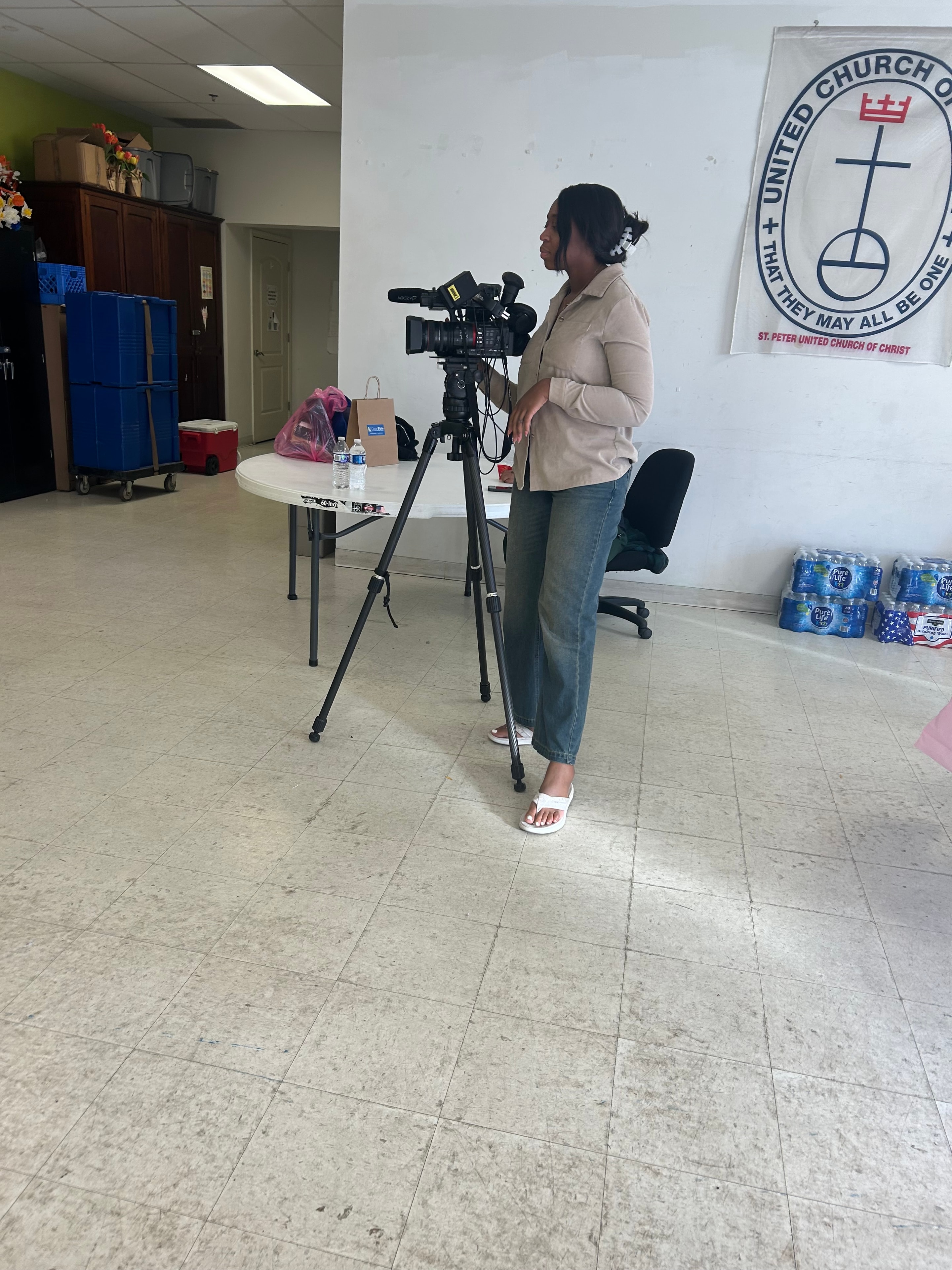 Videographer setting up camera equipment inside St. Peter United Church of Christ at Operation Warm Hearts