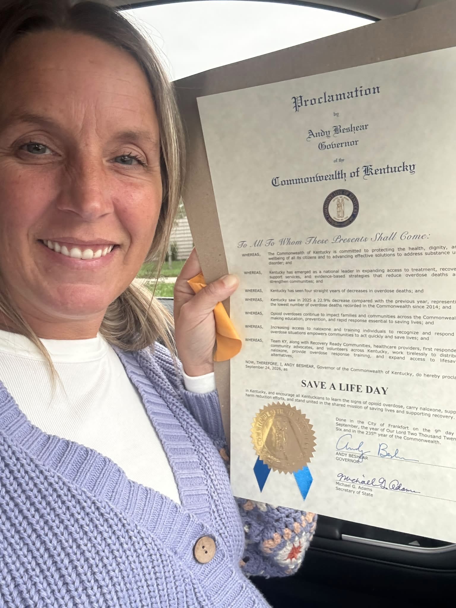 Jessica Ashby holding Governor Andy Beshear's official proclamation declaring Save a Life Day in Kentucky